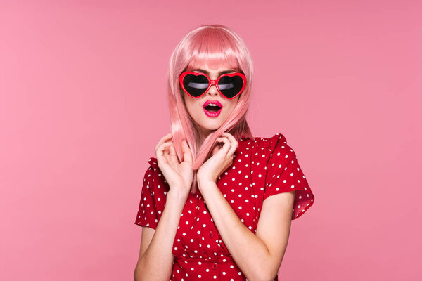 young beautiful woman in pink wig and sunglasses posing in studio 