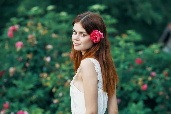 Bahçesinde Kırmızı Çiçekli Güzel Bir Kadın — Stok fotoğraf