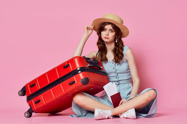 Young woman with red suitcase in studio