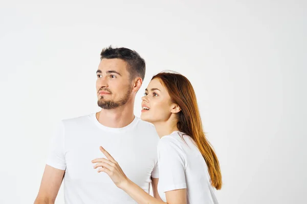 Young  couple  in studio  looking away on isolated background