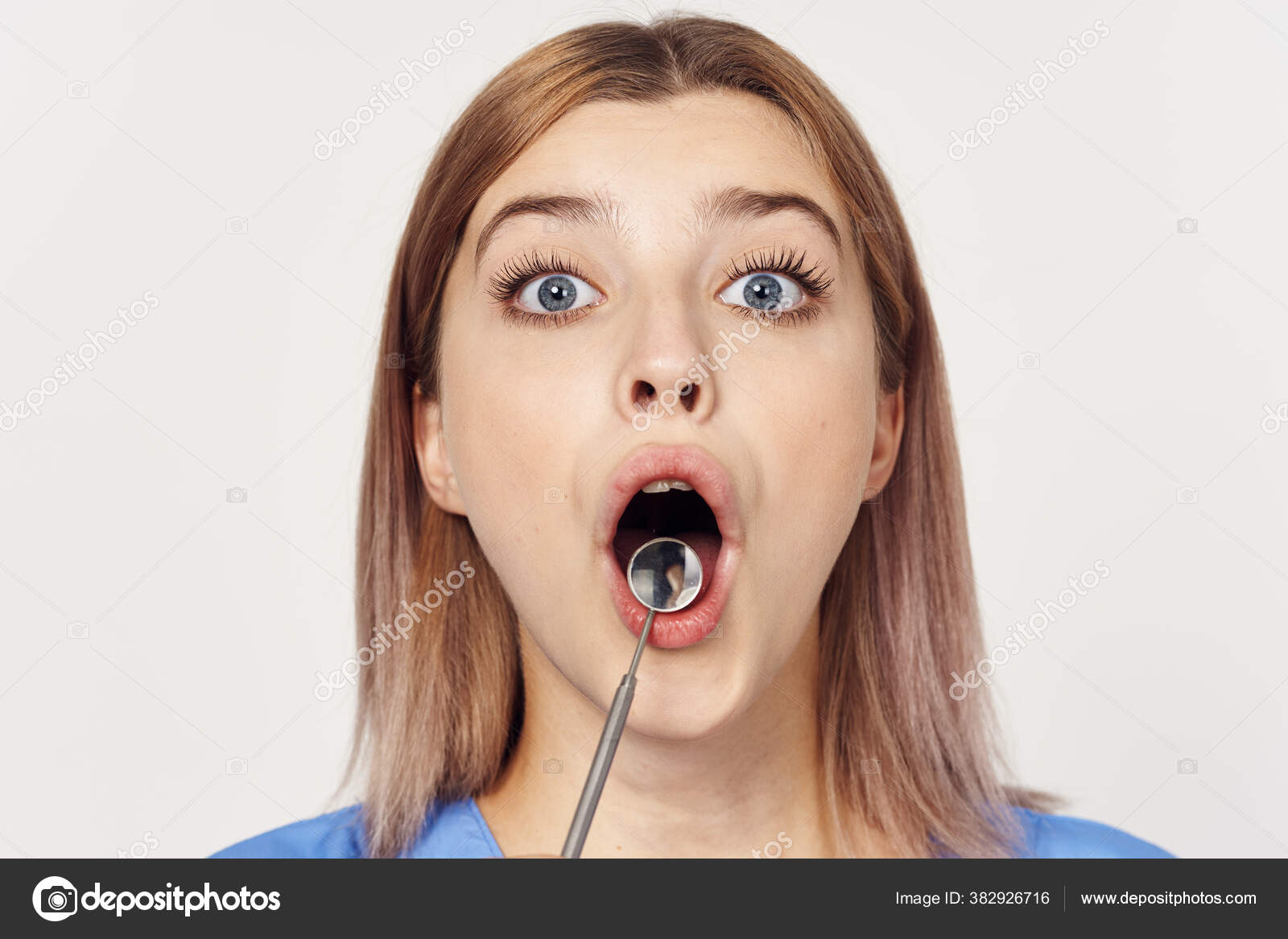 Young Nurse Holding Dental Mirror Tool Studio Shot Stock Photo by