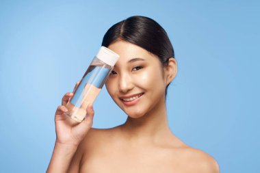 Stüdyo çekimi. Genç Asyalı kadın portresi ve güzellik ürünü.