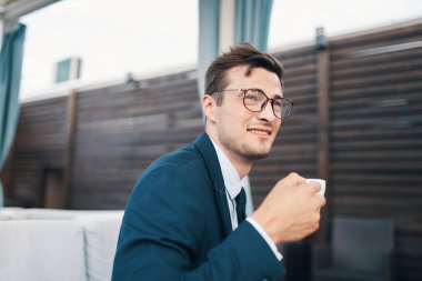 Kafede dizüstü bilgisayarla çalışan yakışıklı bir iş adamı.