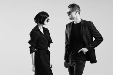 Stüdyoda poz veren güneş gözlüklü güzel bir çift. Siyah ve beyaz.   