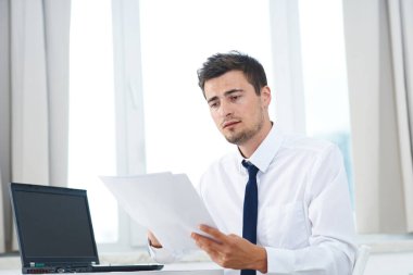 Laptop bilgisayar okuyabilen genç ve yakışıklı iş adamı 