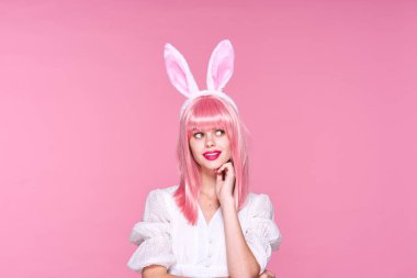 Tavşan kulaklı genç bir kadın stüdyoda poz veriyor. 