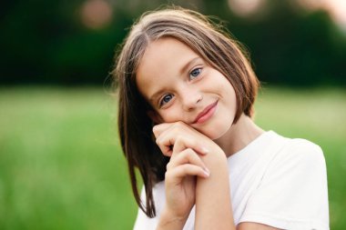 Genç tatlı kız çayırda eğleniyor.