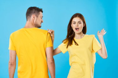 Stüdyoda izole edilmiş arka planda poz veren tişörtlü güzel bir çift.