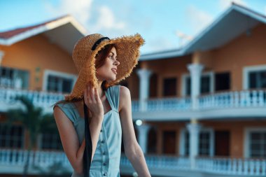   Tropik tatil köyünde hasır şapkalı genç bir kadın. 