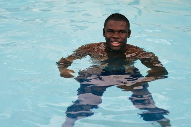 Havuzda poz veren genç yakışıklı adam.