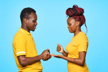 Stüdyoda mavi arka planda oynayan genç ve güzel bir çift.