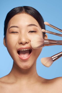 Stüdyo çekimi. Fırçalı genç Asyalı kadın.