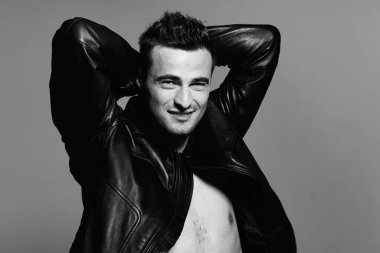 Stüdyoda poz veren siyah deri ceketli yakışıklı bir adamın portresi. Siyah ve beyaz  