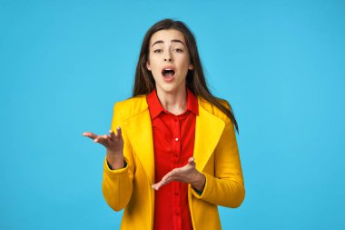 Mavi arka planda sarı ceketli, kafası karışmış genç bir kadın..