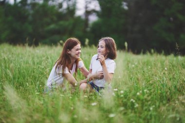 Genç anne ve kızı papatya tarlasında eğleniyorlar.