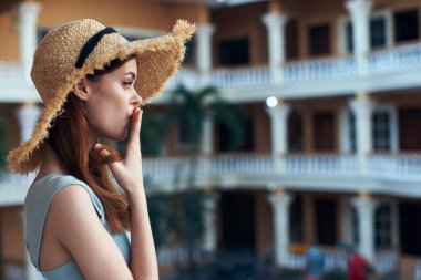   Tropik tatil köyünde hasır şapkalı genç bir kadın. 