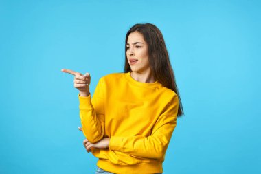 Stüdyoyu gösteren genç bir kadın mavi arka planda izole edilmiş. 