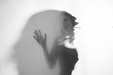 Perdenin arkasında duran genç ve güzel kadın.