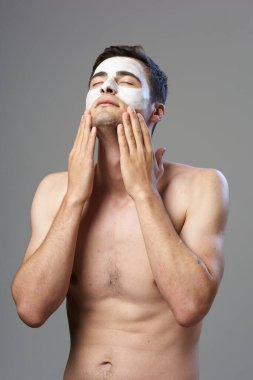 Genç adam yüz maskesi takıyor. 