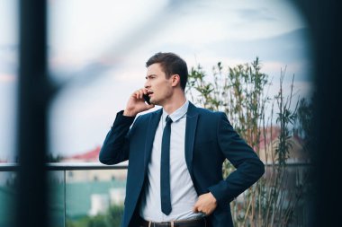 Genç ve yakışıklı iş adamı akıllı telefonları alıyor.  