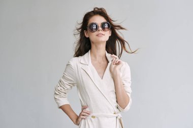 Stüdyoda poz veren güneş gözlüklü güzel bir kadın.  