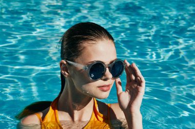 Genç ve güzel bir kadın havuzda dinleniyor.  