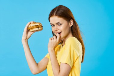 Hambyrger 'ı olan güzel bir kadın. Stüdyo çekimi