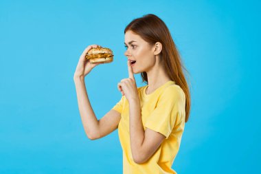 Hambyrger 'ı olan güzel bir kadın. Stüdyo çekimi