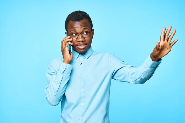 Akıllı Telefondan Konuşan Genç Bir Afrikalı Mavi Arka Planda Izole — Stok fotoğraf
