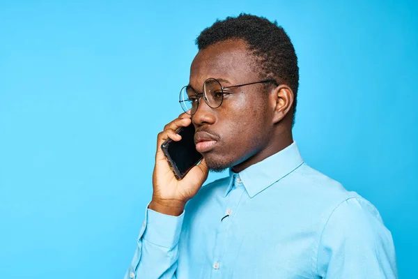 Jovem Homem Africano Com Smartphone Isolado Fundo Azul — Fotografia de Stock
