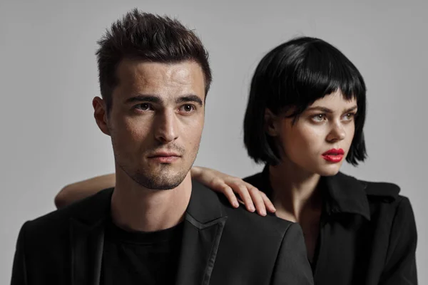 Young beautiful couple in black posing in studio