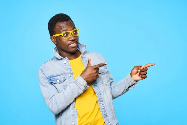 Young man  pointing away  isolated on blue background