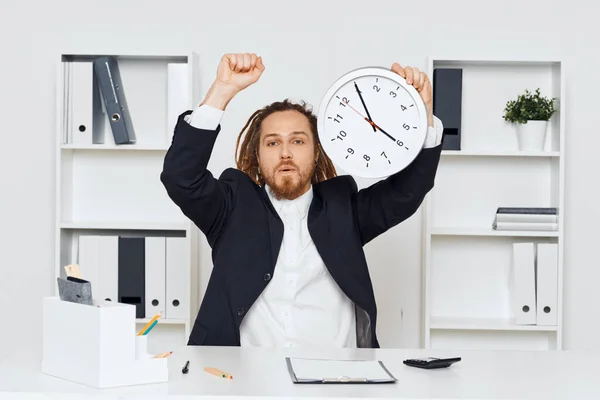Young businessman sitting in the office  with big clock