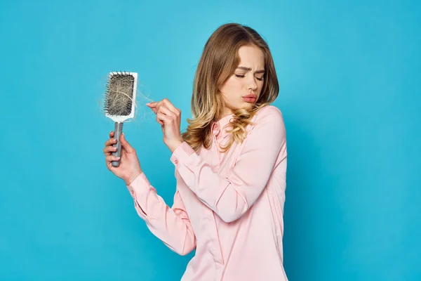 Young beautiful woman with hair brush in studio