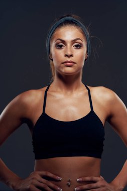 Stüdyo çekimi. Tecrit edilmiş, kaslı, genç bir kadın.   