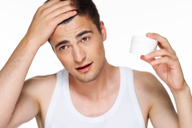 Stüdyo. Güzellik ürünleriyle genç yakışıklı adam.