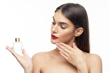 Stüdyoda parfüm şişesi tutan güzel bir kadın.