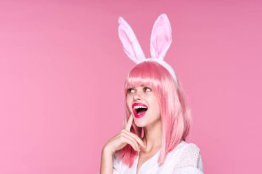 Tavşan kulaklı genç bir kadın stüdyoda poz veriyor. 