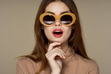 Stüdyoda poz veren güneş gözlüklü güzel bir kadın. 