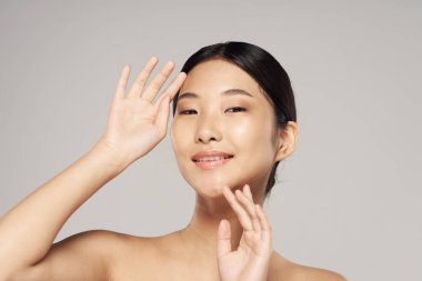 Gri arka plan üzerinde poz genç Asyalı kadın