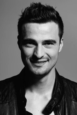  Gülümseyen genç portresi. Karanlık arka plandaki adam.  