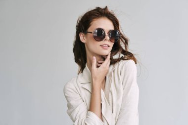 Stüdyoda poz veren güneş gözlüklü güzel bir kadın.  