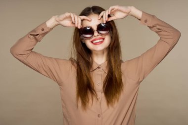 Stüdyoda poz veren güneş gözlüklü güzel bir kadın. 