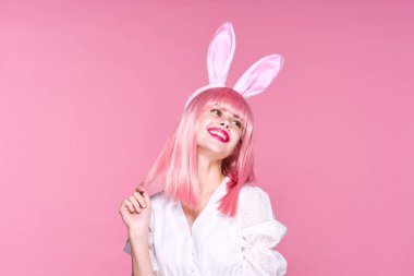 Tavşan kulaklı genç bir kadın stüdyoda poz veriyor. 