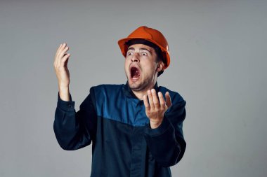 Stüdyo çekimi. Turuncu kasklı sanayi işçisi korkuyor. 