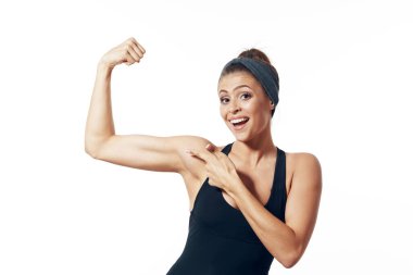 Genç kadın kaslarını gösteriyor. 