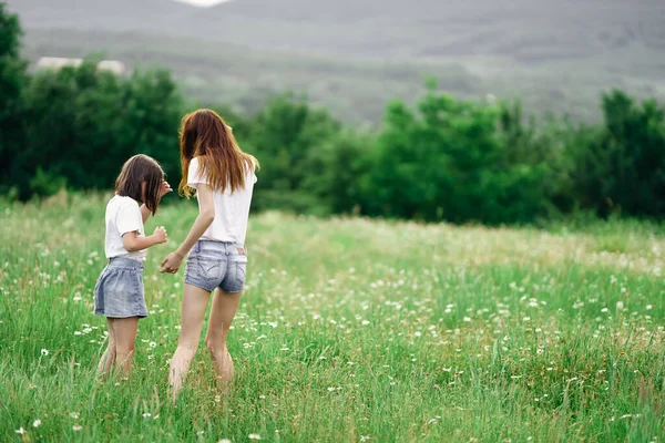 若いです母と彼女の娘持っています楽しいです上のカモミールフィールド — ストック写真