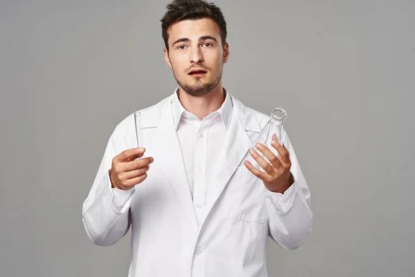 Young Handsome Doctor Lab Coat Holding Test Tubes Grey Background — Stock Photo, Image