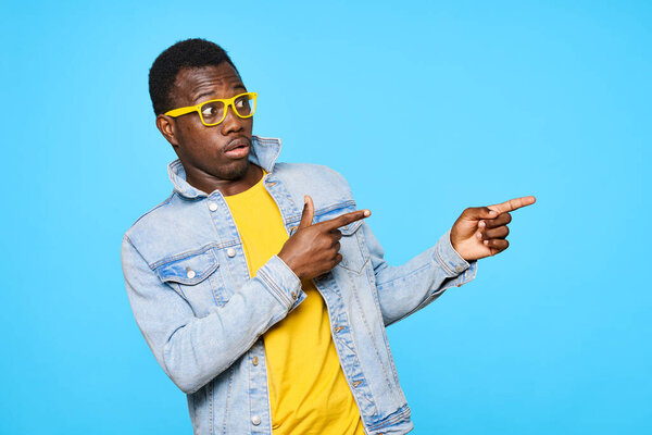 Young man  pointing away  isolated on blue background
