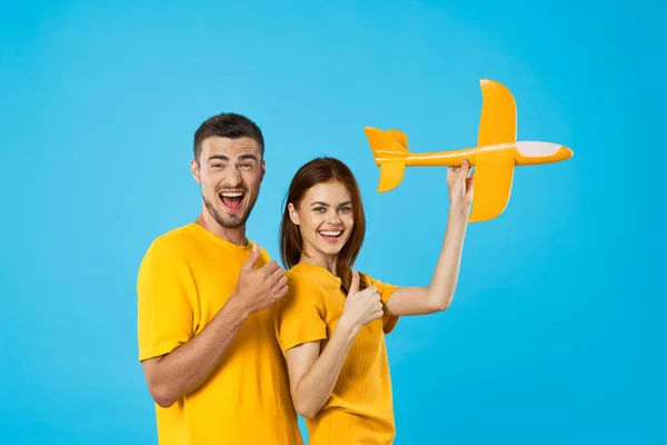 Jong Mooi Paar Spelen Met Geel Speelgoed Vliegtuig Blauwe Achtergrond — Stockfoto